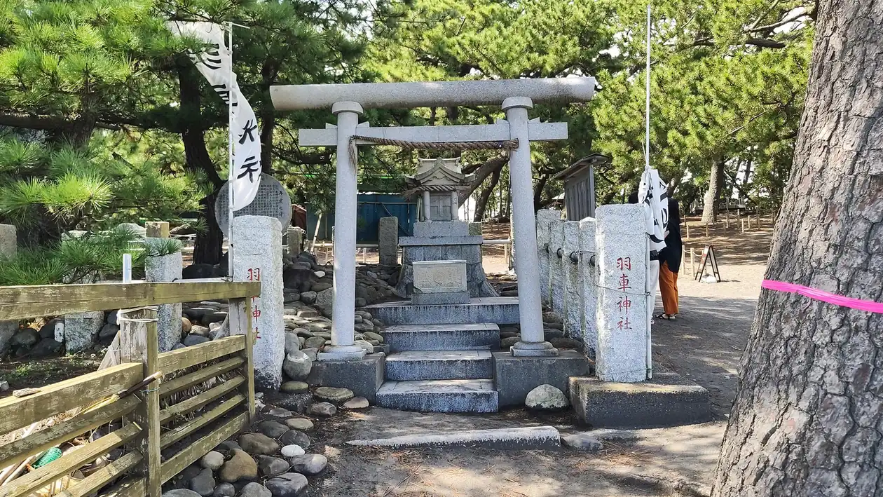 The stone torii of Hagoruma Shrine beside the Hagoromo pine at Miho