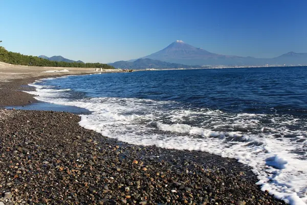 Mt. Fuji over the pebble beach and surf at Miho